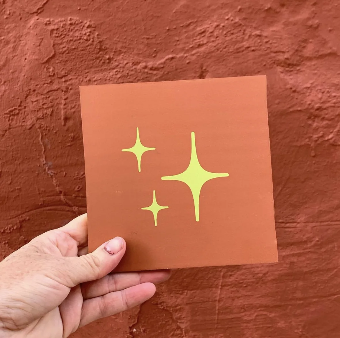 Cartulina naranja con tres estrellas amarillas serigrafiadas