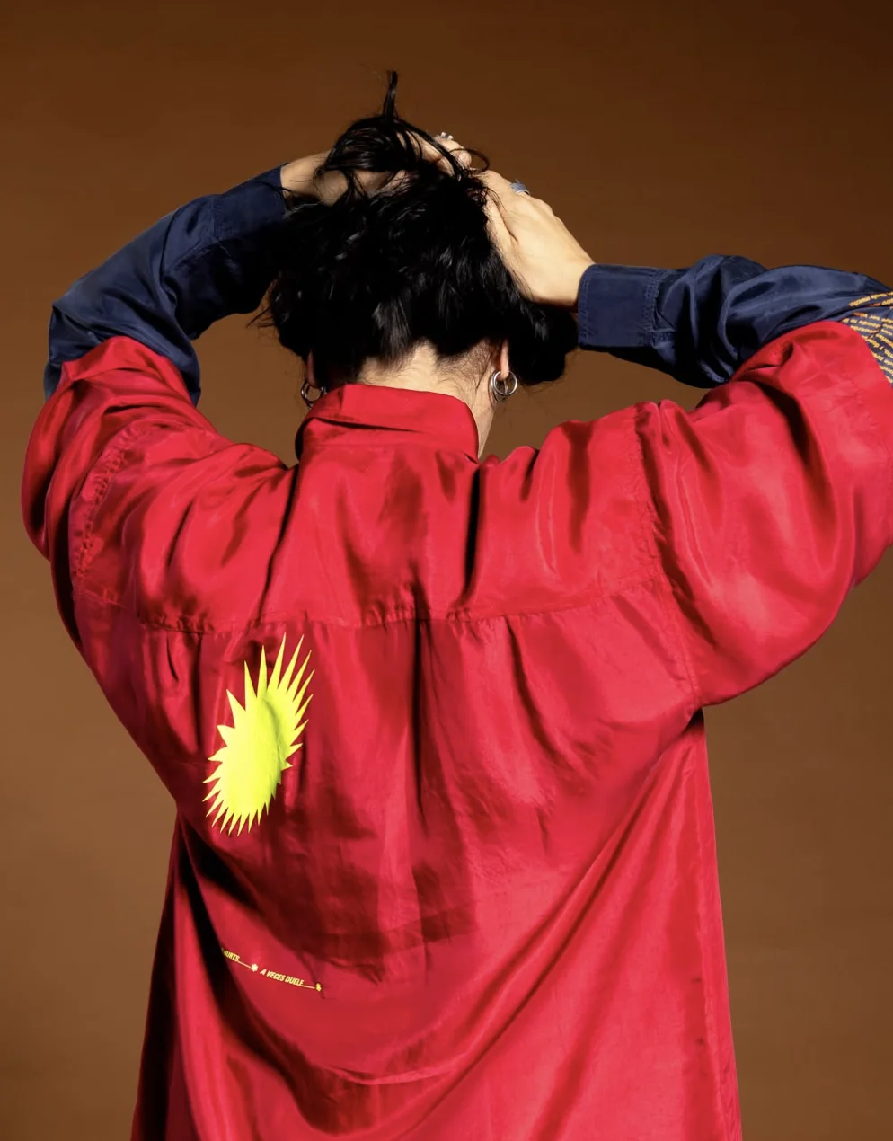 Espalda de una chaqueta roja estampada a mano con un sol amarillo
